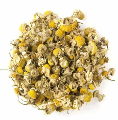 Heap of dried chamomile flowers on a white background