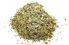 Pile of dried green spearmint herbs on a white background